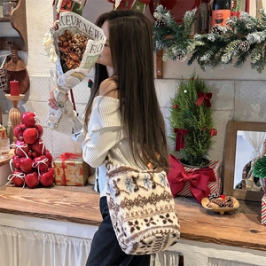 Detail of plush winter bucket bag with snowflake patterns and soft faux fur texture