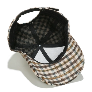 Detailed close-up of houndstooth wool baseball cap showing thick fabric texture and stitching