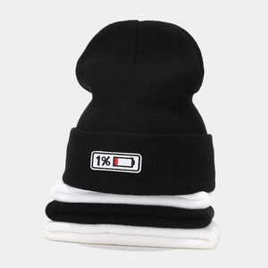 Detail of knitted beanie featuring 1% battery percentage embroidery patch in creative style