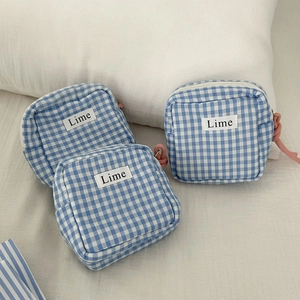 Detailed view of blue checkered canvas mini storage bags with pink zipper details