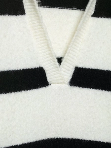 Macro detail of V-neckline and soft striped knit texture of the winter sweater