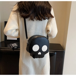 Detail showing high-shine black PU leather skull crossbody bag with white heart-shaped nose