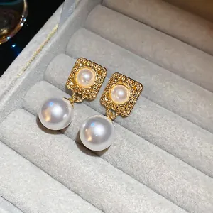 Vintage-Ohrringe mit Goldrand und Perlen in einer luxuriösen grauen Schmuckschatulle