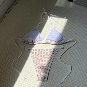 Detailed flat lay of white lace hollow bikini with halter top and side tie bottoms