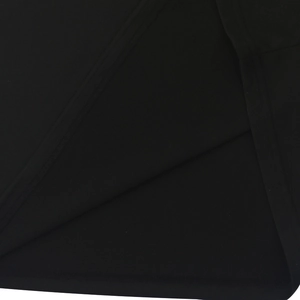 Detailed close-up showing the stitching and texture of the black polo shirt hem