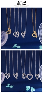 Vue détaillée des pendentifs en cœur sertis de zircons sur une surface texturée bleu foncé