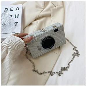 Detail of creative camera-shaped evening bag with glitter finish and silver chain strap