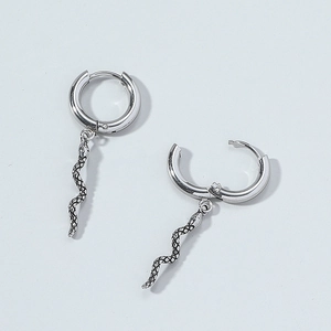 Detailed macro view of silver snake dangle earrings in trendy titanium steel metal