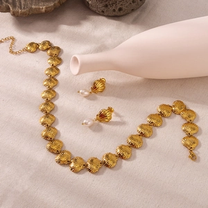 18k gold plated shell necklace and pearl drop earrings set on elegant beige background