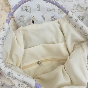 Gros plan de l'intérieur du sac matelassé avec poche zippée et doublure florale