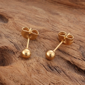 Minimalist 18K gold daisy pendant necklace on a natural rustic wood background