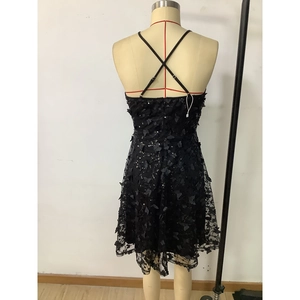 Détail du dos nu avec appliques papillons et paillettes sur une robe de soirée noire