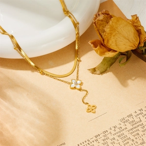 Élégant collier double épaisseur en or avec pendentifs trèfle en nacre et strass