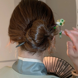 Detailed view of Chinese butterfly hair stick with green beads on a model's hairstyle