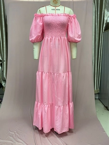 Close-up of pink off-shoulder satin dress with smocked bodice and tiered ruffle skirt