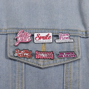 Lot de 6 pin's créatifs en émail rose avec citations sur une veste en denim