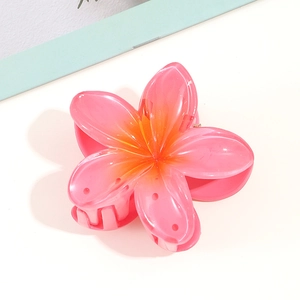 Macro detail of Frangipani hair claw clip with pink and orange resin gradient effect