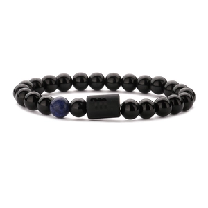 Makroaufnahme von Sternzeichen-Perlenarmband mit Tigerauge und Skorpion-Anhänger