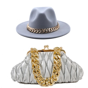 Gray wool fedora with gold chain detail paired with a silver pleated handbag and strap