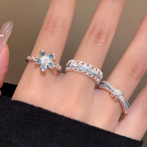 Detailed view of silver flower ring set with light blue enamel and sparkling rhinestones