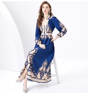 Dettaglio del vestito lungo con scollo a V, stampa paisley dorata e maniche a lanterna