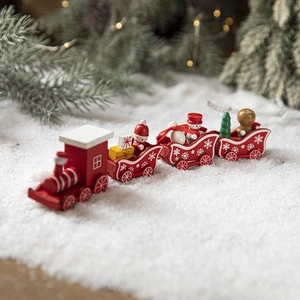 Red wooden Christmas train set with festive figurines on a snowy background