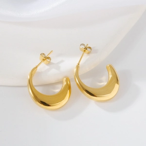 Macro shot of polished gold irregular crescent drop earrings with a glossy mirror finish