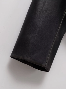 Close-up of premium black leather texture and fine grain detail on motorcycle jacket sleeve