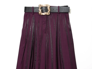 Detailansicht der lila Satinhose mit schwarzem Gürtel und goldener Schnalle