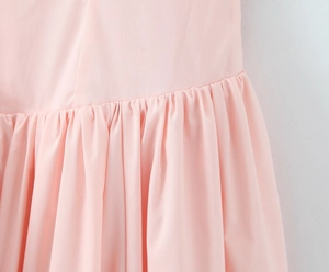 Close-up of pink pleated waist detail and stitching on this stylish halter dress