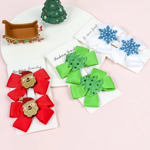 Close-up of three festive Christmas bow hair clips with glitter Santa and tree accents