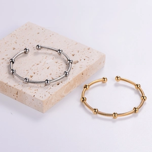 Detailed shot of 6mm metal beads on gold and silver woven steel wire bracelets