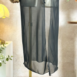Close-up of semi-transparent black mesh cover-up showing lightweight fabric texture