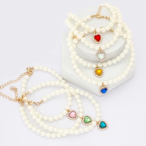 Detail view of heart crystal pearl pet necklaces in seven vibrant colors on display