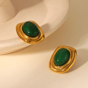 Vue macro des boucles d'oreilles vintage dorées à l'or 18K avec pierre verte ovale