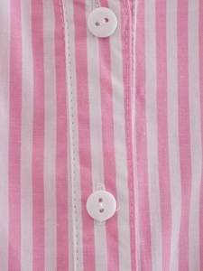 Close-up of pink striped shirt placket with white round buttons and fine stitching