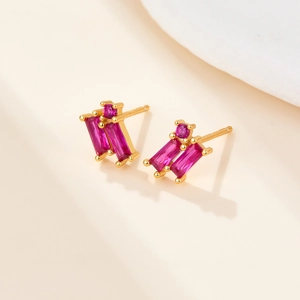 Detail of gold-plated S925 silver earrings with rectangular ruby-colored zircons
