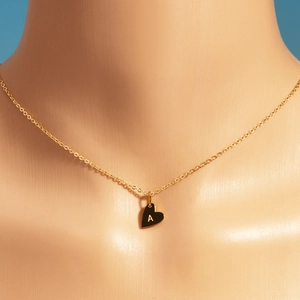 Élégant collier avec pendentif coeur doré et lettre A gravée sur un mannequin