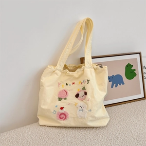 Detail of cute puppy embroidery and Peach Puppy text on beige canvas tote bag