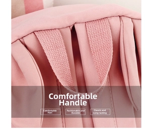 Close-up of a pink school backpack featuring a wide, durable fabric carrying handle