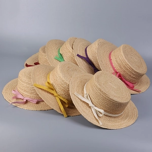 Flat top raffia sun hats in multiple vibrant colors with woven bow details