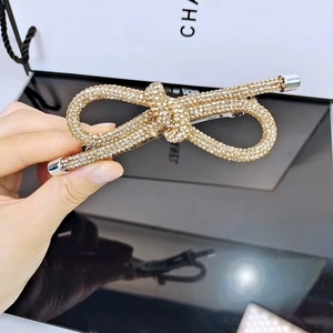 Dettaglio del fermaglio a fiocco con strass brillanti e base in lega dorata elegante