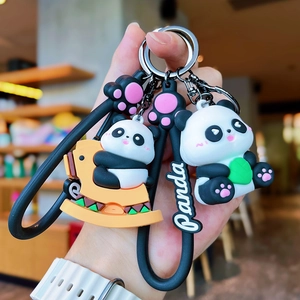 Detail of cute cartoon panda keychain with bamboo and PVC charm on black strap