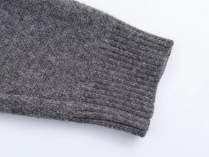 Detailed close-up of dark grey knitted cuffs showing high-quality wool texture and ribbing