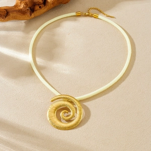 Collier avec pendentif soleil en spirale dorée et cordon tressé en vue de dessus à plat