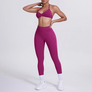 Dettaglio del reggiseno sportivo allacciato al collo prugna e leggings yoga a vita alta