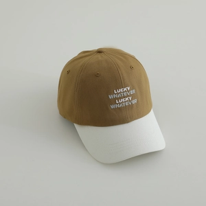 Close-up of brown and white baseball cap with Lucky Whatever embroidery details