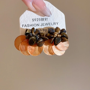 Detailed close-up of S925 silver needle earrings with brown shell and amber resin beads