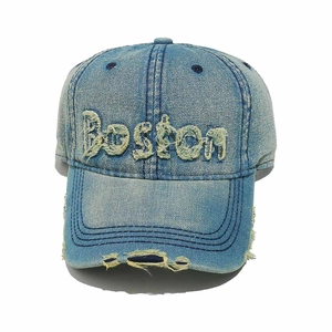 Dettaglio del ricamo Boston e dei fori usurati su questo cappellino di jeans slavato
