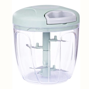 Close-up of manual food processor with sharp blades, clear container and light green lid